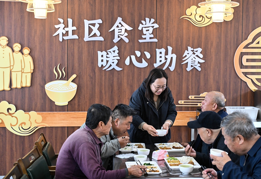 在江苏省扬州市江都区邵伯镇甘棠社区幸福邻里食堂,社区工作人员(左三)给老年居民端汤(2026年4月29日摄)。